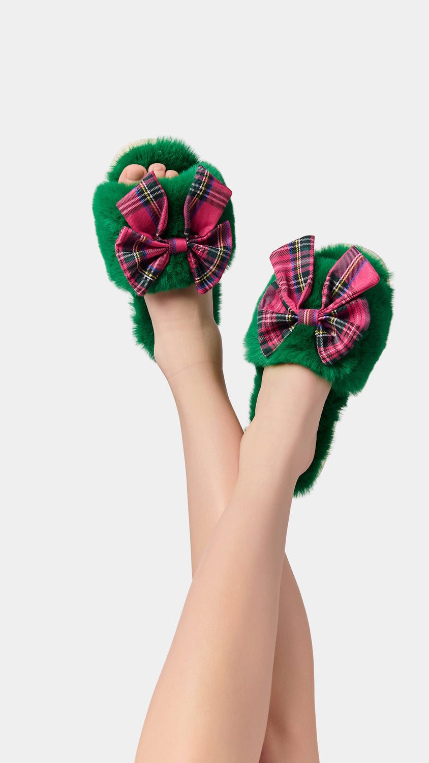 Shiraleah Scottie Slippers in green faux fur with pink and red tartan bows, polyester and PVC, worn on model, front view