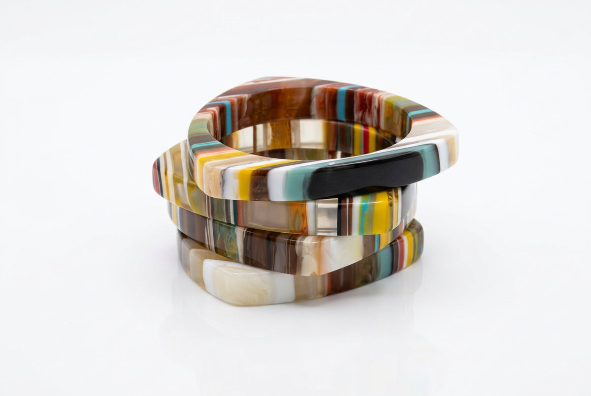 Triangle multicolor resin bangle bracelets in brown, cream, yellow and black stripes, stacked side view.