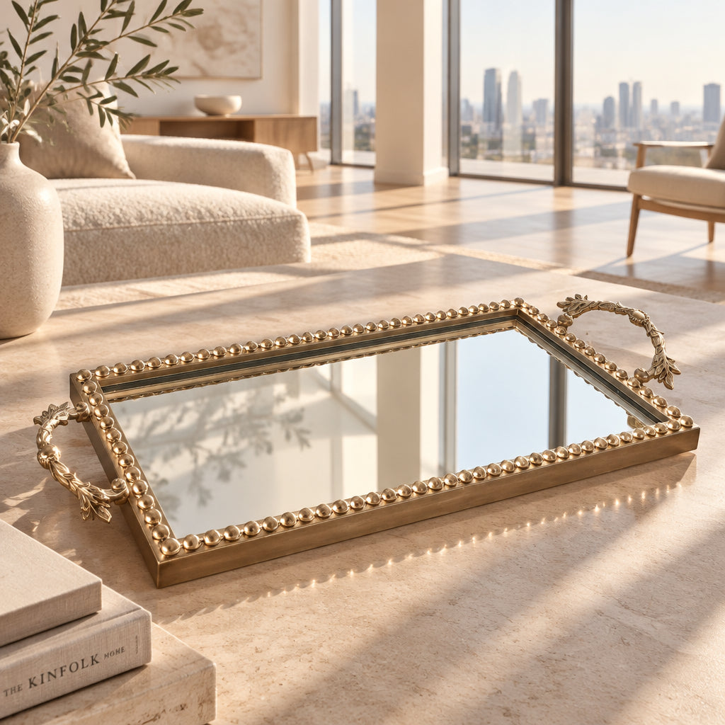 A rectangular decorative mirror with an ornate gold-toned beaded frame and matching side handles, resting on top of cardboard shipping boxes.