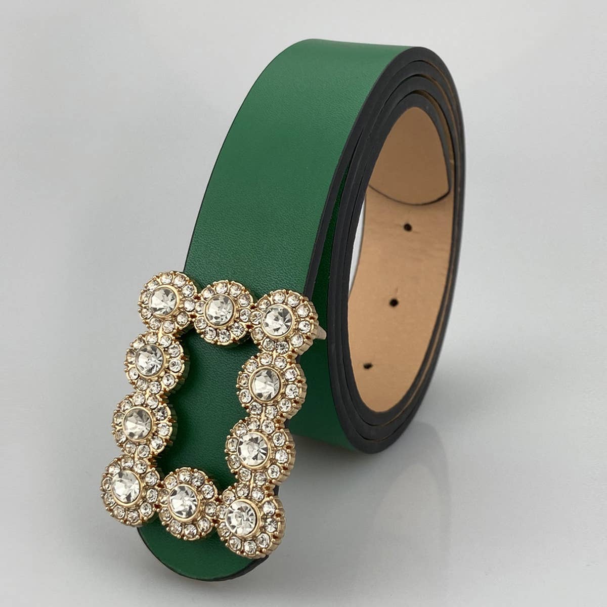 Green belt with a decorative buckle on a light gray background