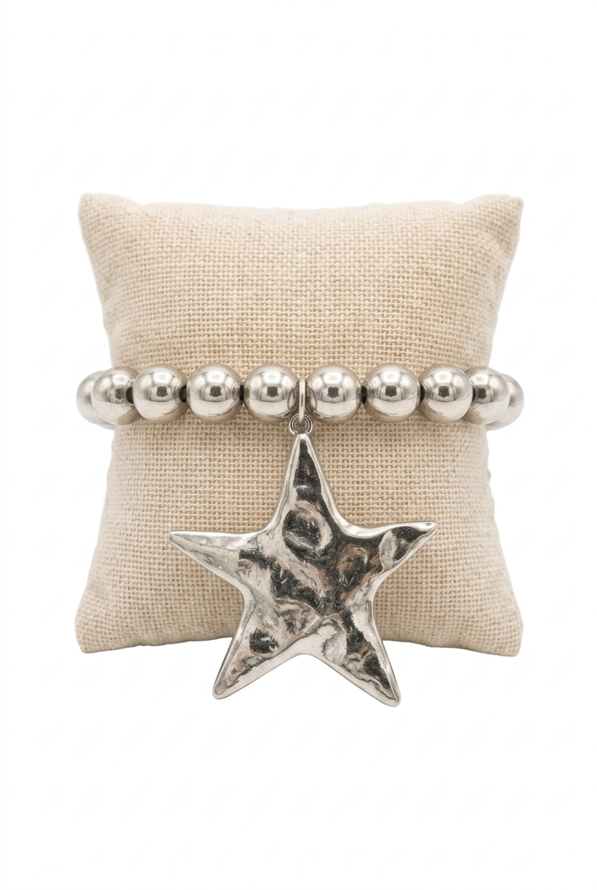 Accessories to Go silver-tone beaded bracelet with a large hammered star charm on a linen pillow
