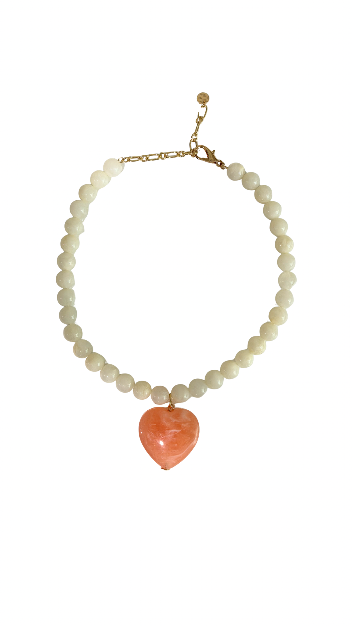 Necklace with white beads and a heart-shaped coral pendant on a white background