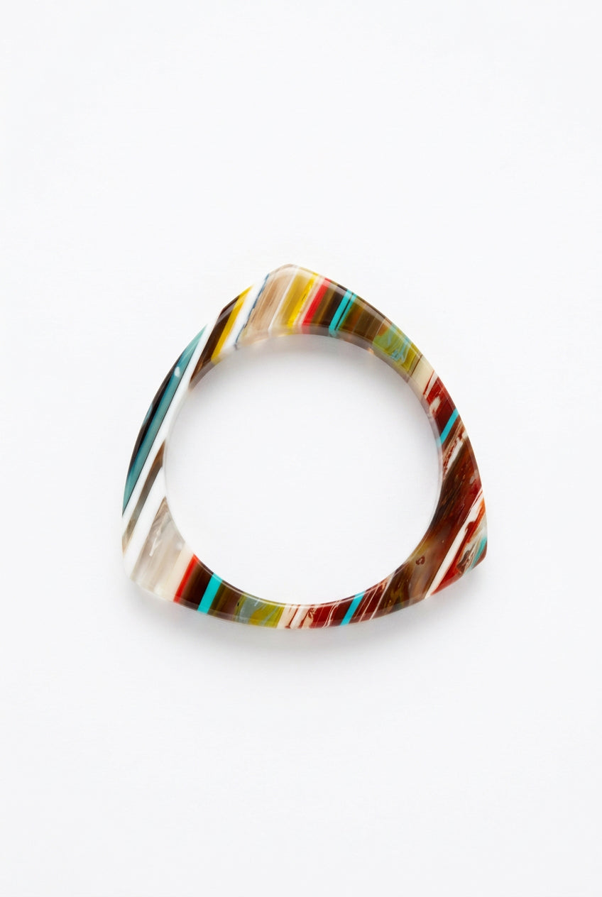 Triangle multicolor resin bangle bracelet with red, brown, teal and cream stripes, top view.