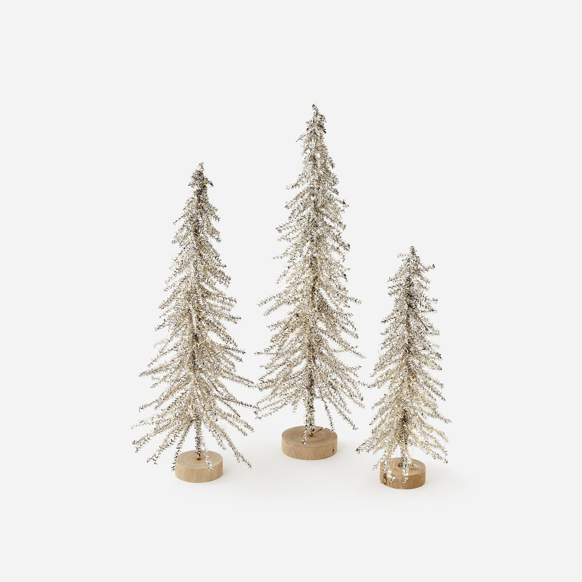 Lit silver tinsel Christmas trees with plug-in adapter, shown in three sizes, full view