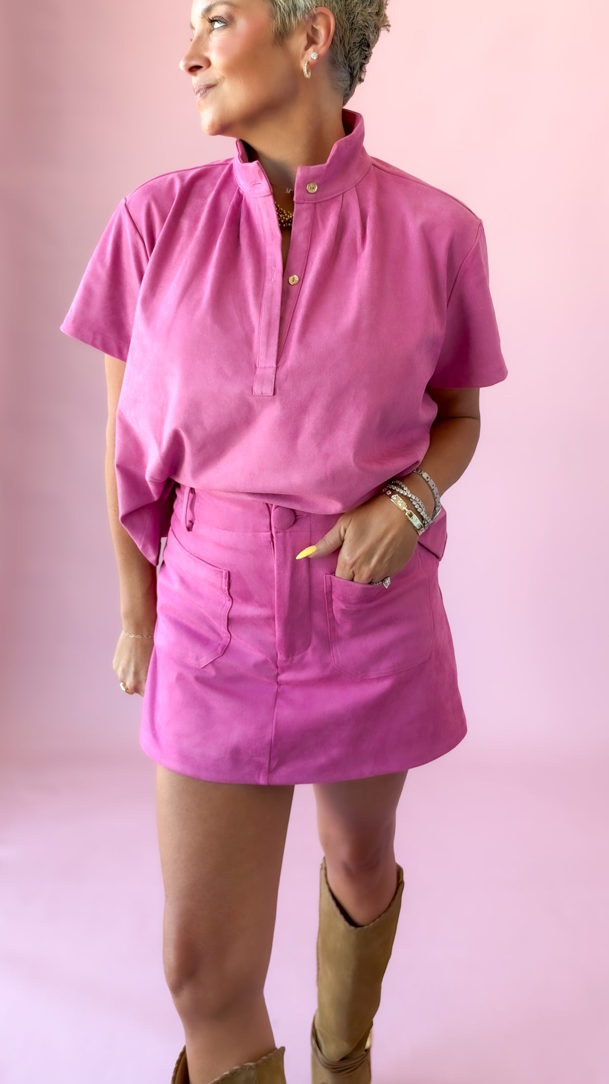 Pink suede top styled with matching skort, angled view