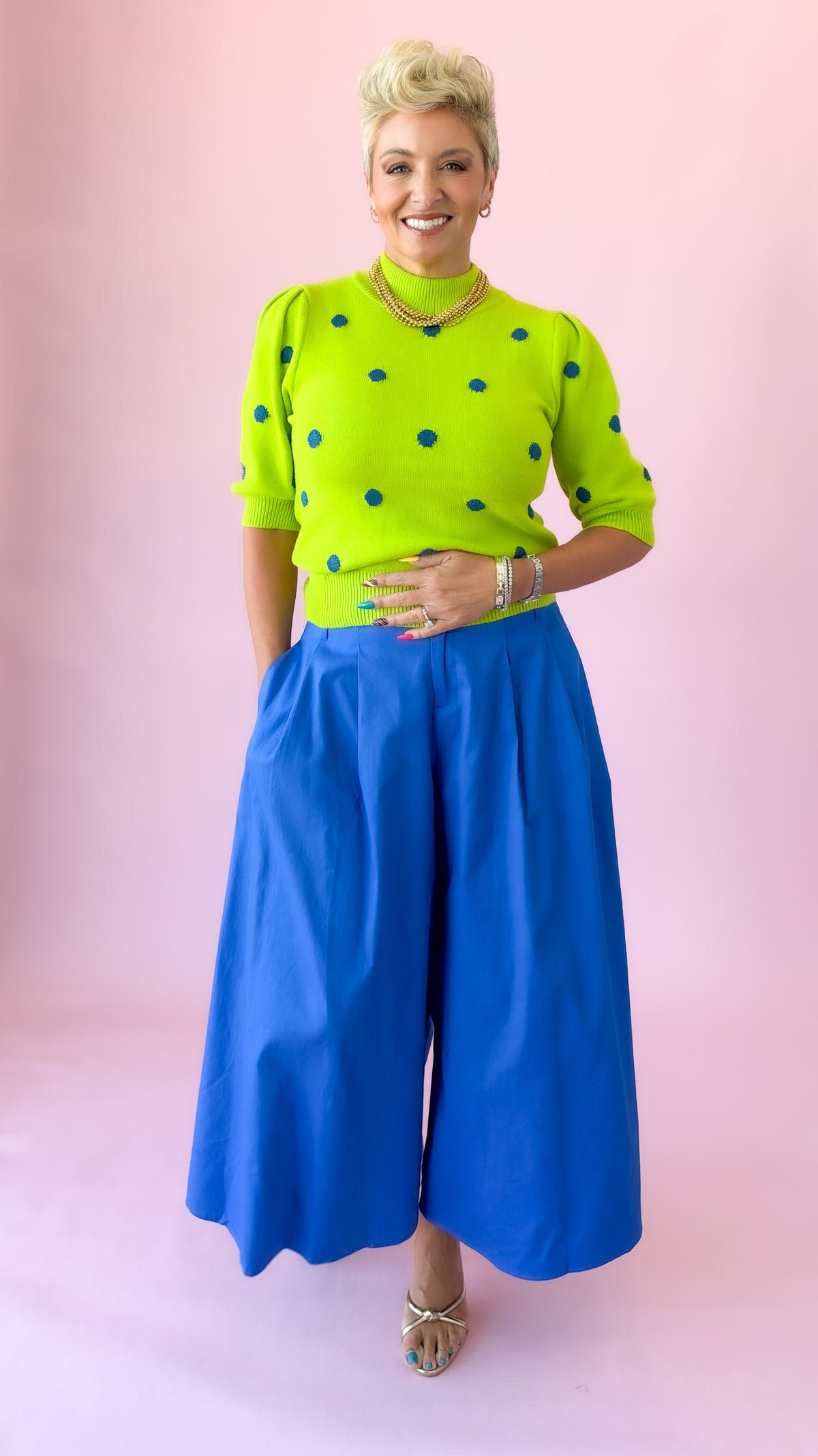 Full-length view of lime dot mock neck sweater with blue wide-leg pants