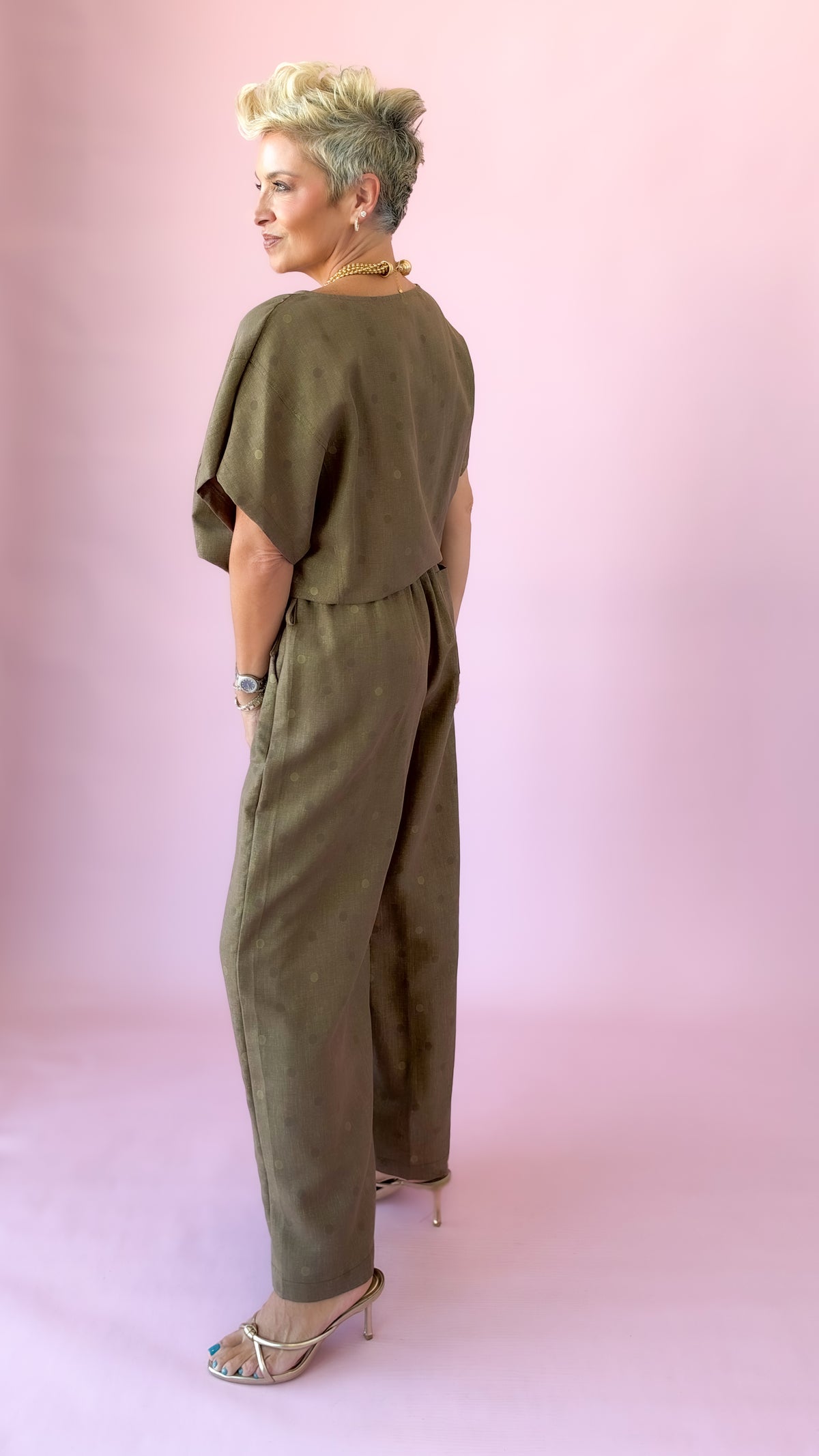 Side view of brown round neck polka dot top with matching wide-leg pants