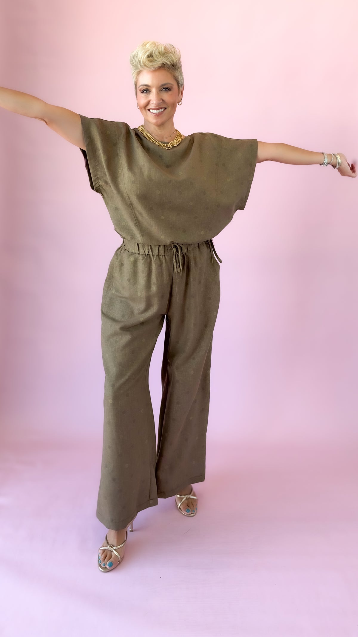 Brown polka dot round neck top shown with arms extended