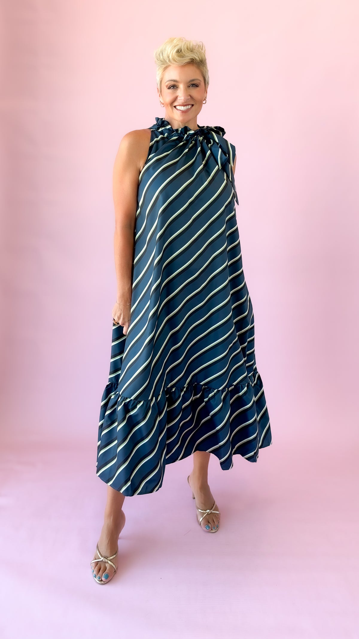 Full-length front view of teal striped tie neck midi dress with heels