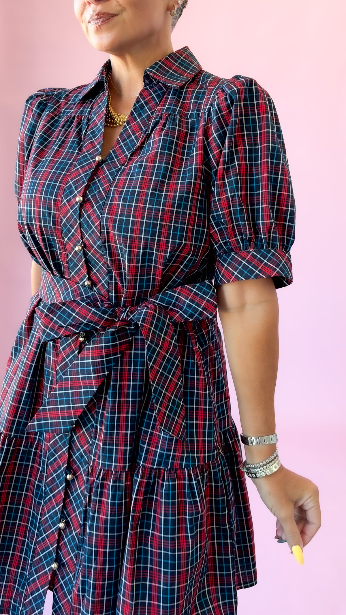 Close-up of the tie waist and puff sleeves on the navy plaid Angelica mini dress