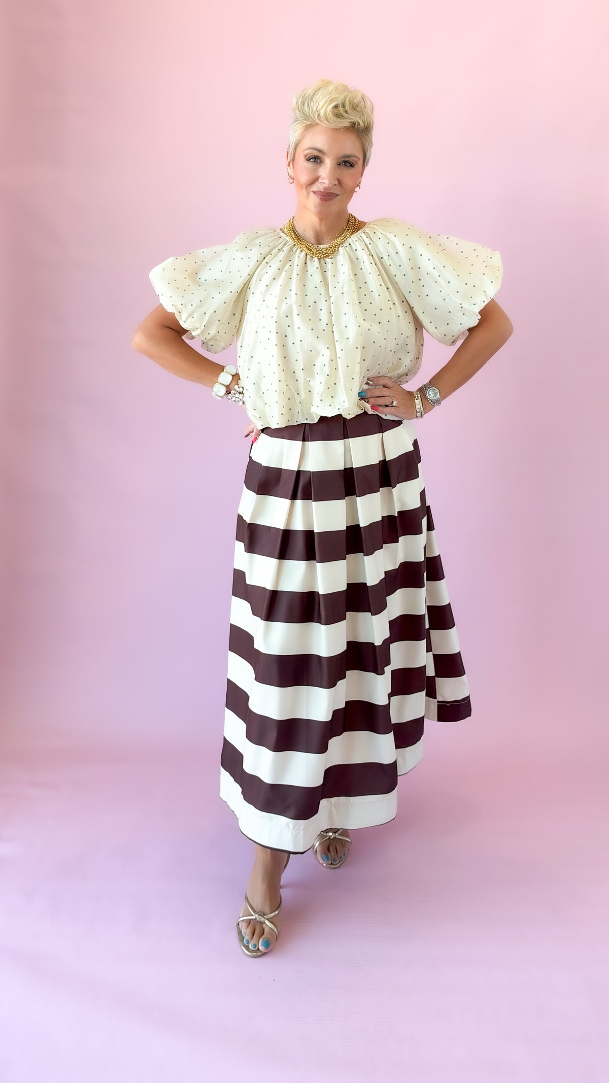 Brown and white striped pleated midi skirt styled with an ivory puff sleeve blouse