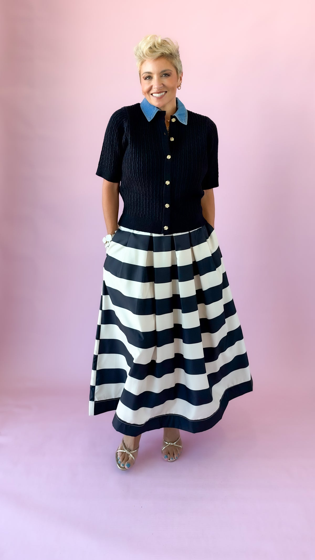 Front view of black and white wide stripe midi skirt worn with hands in pockets