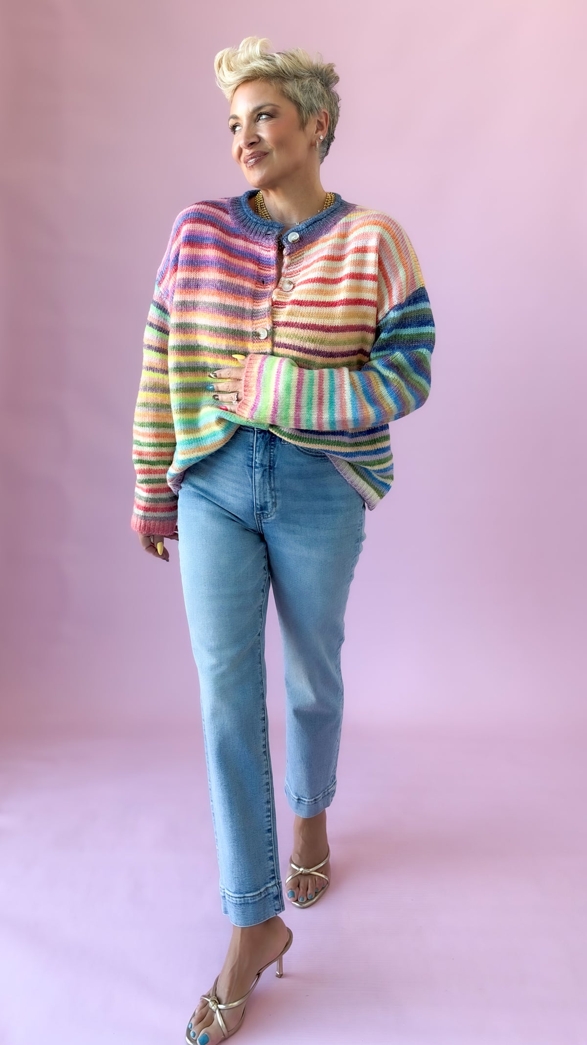 Full-length view of rainbow striped button-up cardigan with jeans and heels