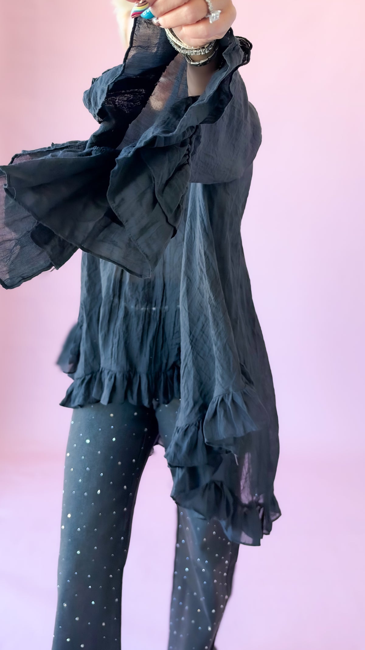 Close-up of the ruffled sleeve on the black oversized bow blouse