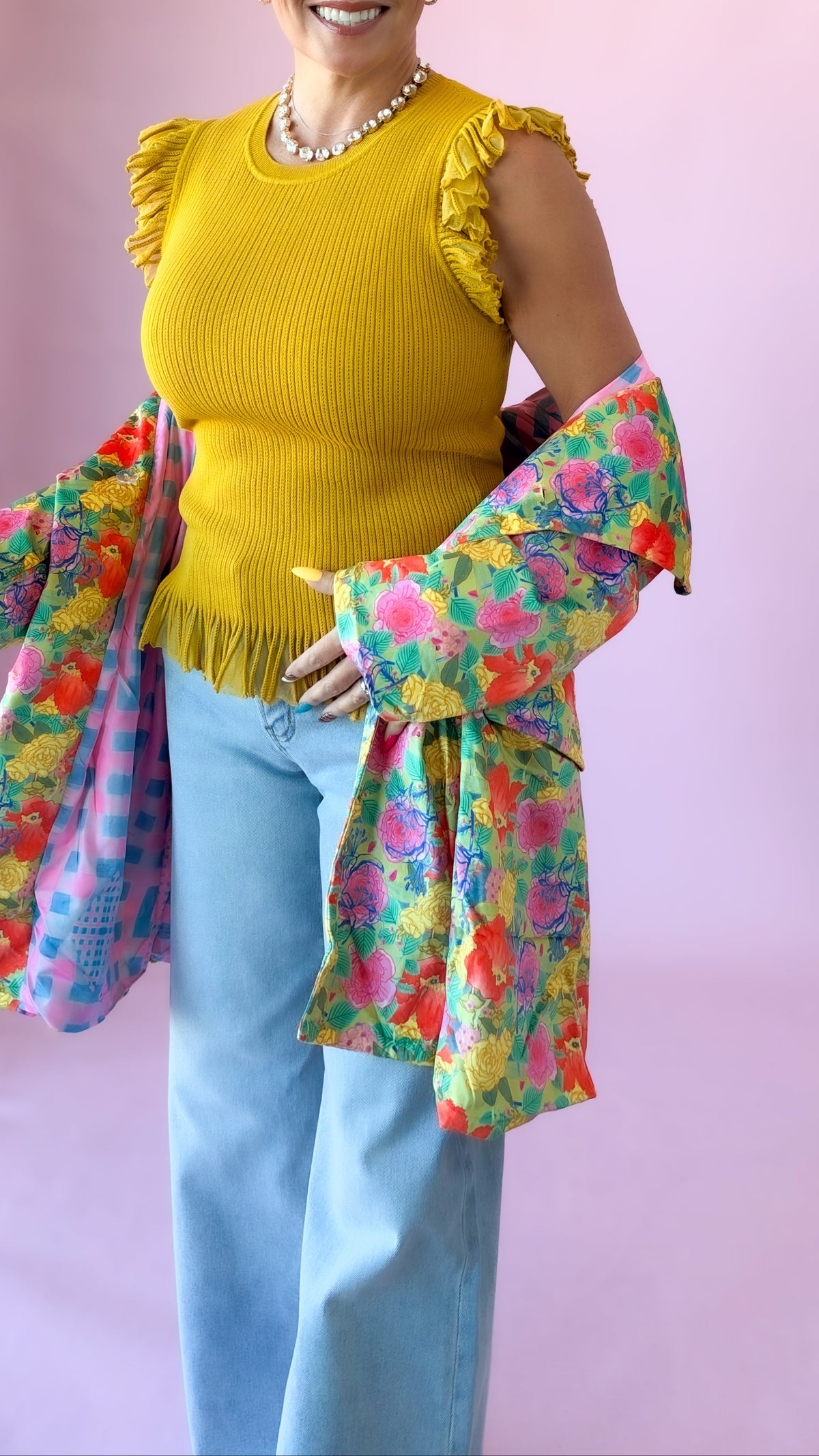 Mustard yellow Chelsea ribbed sweater with flutter sleeves, layered under a colorful floral jacket