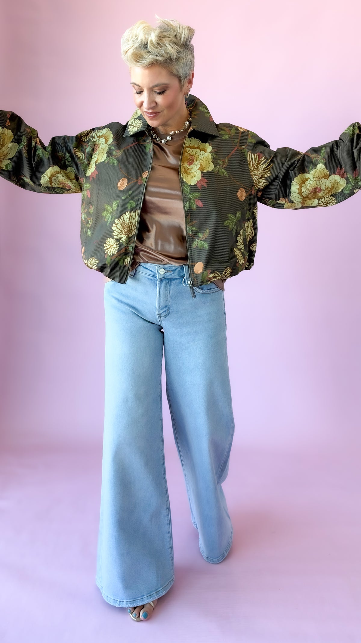 Olive floral crop jacket shown with arms outstretched to display the full silhouette