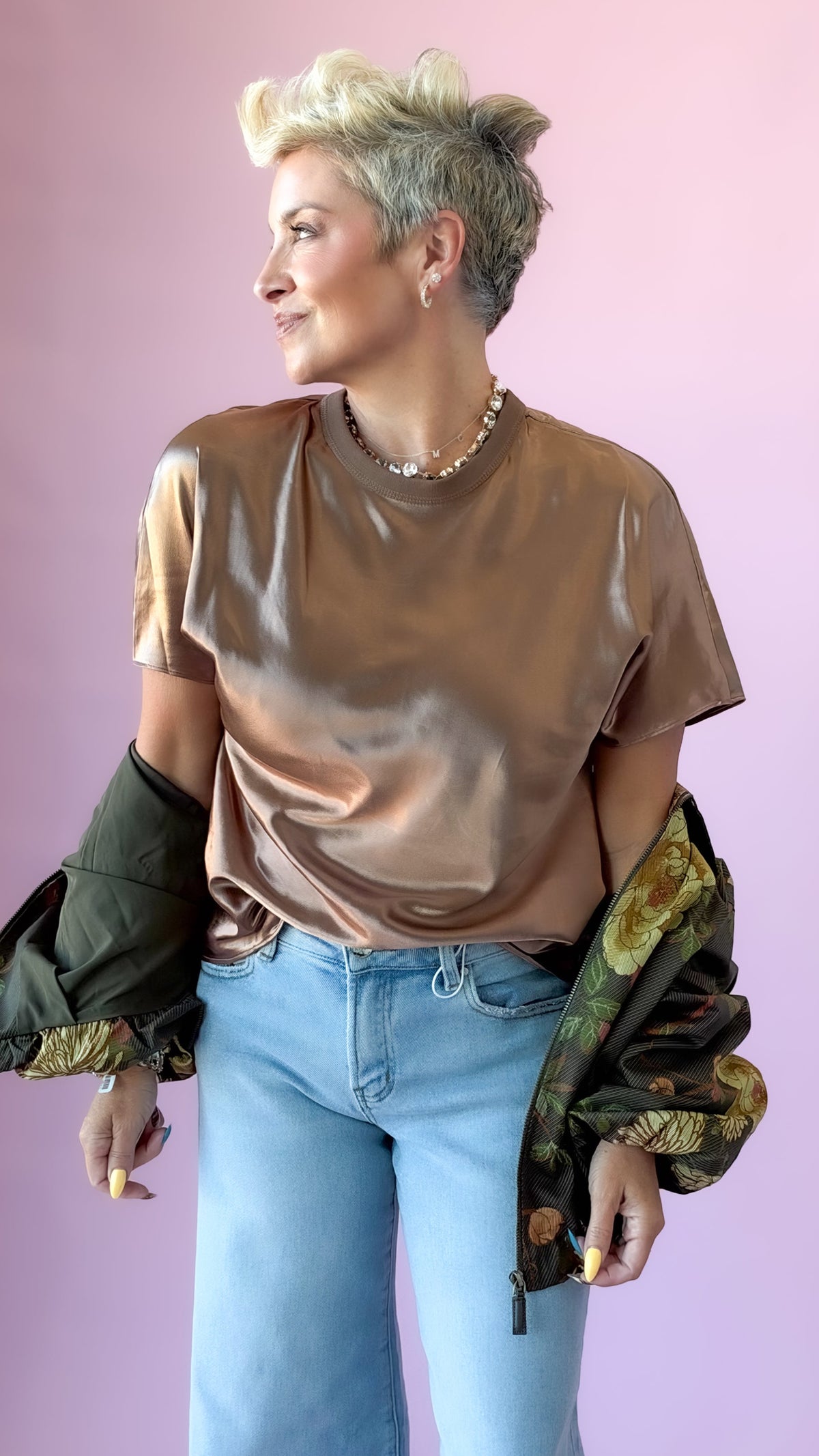 Brown satin crewneck short sleeve top with a camo jacket and light jeans