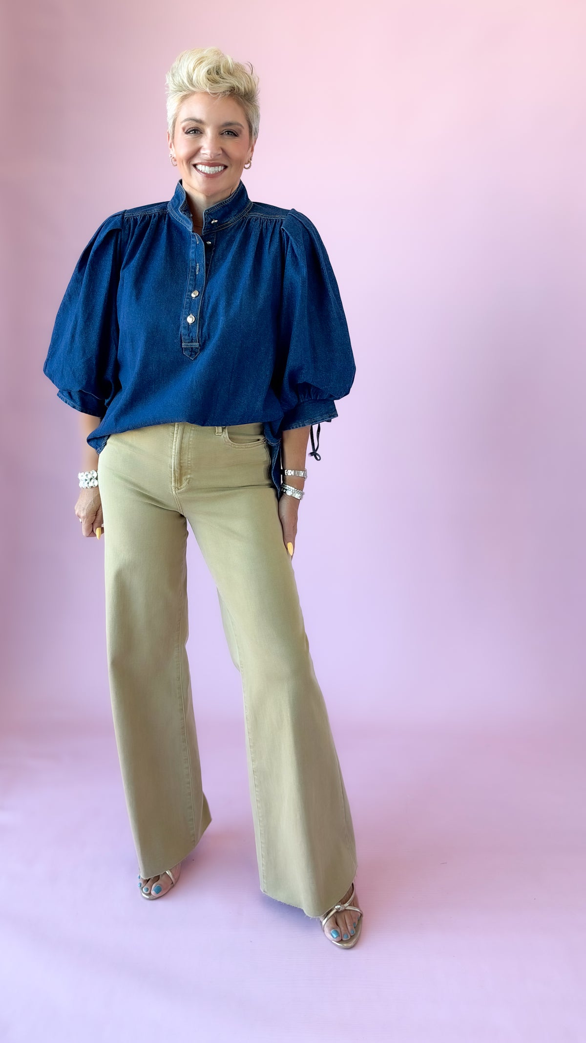 Full-length front view of khaki Fiona flare jeans with a navy puff sleeve blouse