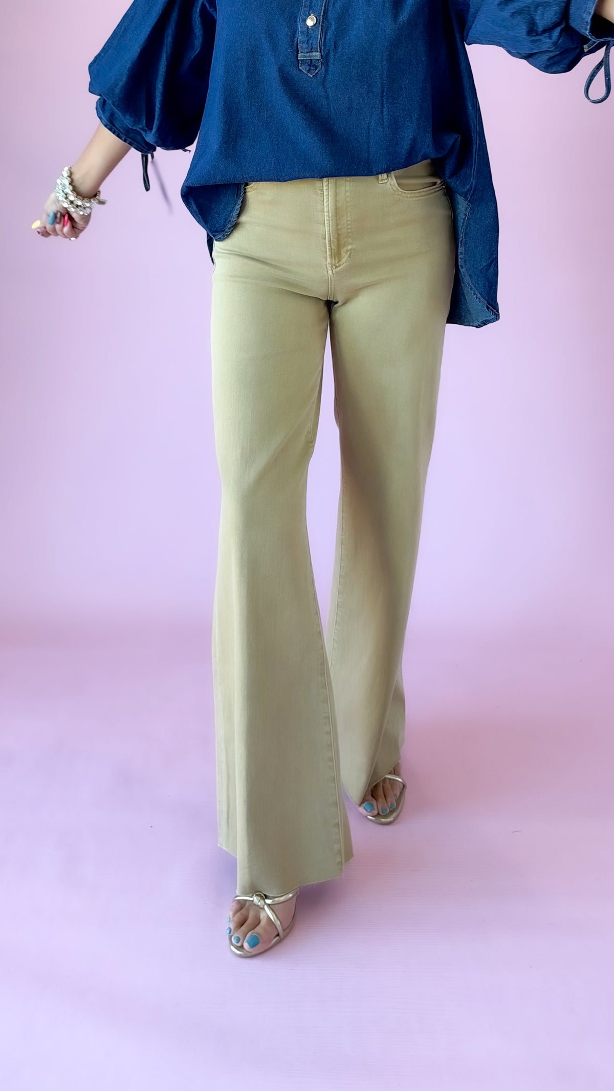 Khaki Fiona high-rise flare jeans shown mid-stride with a navy denim blouse