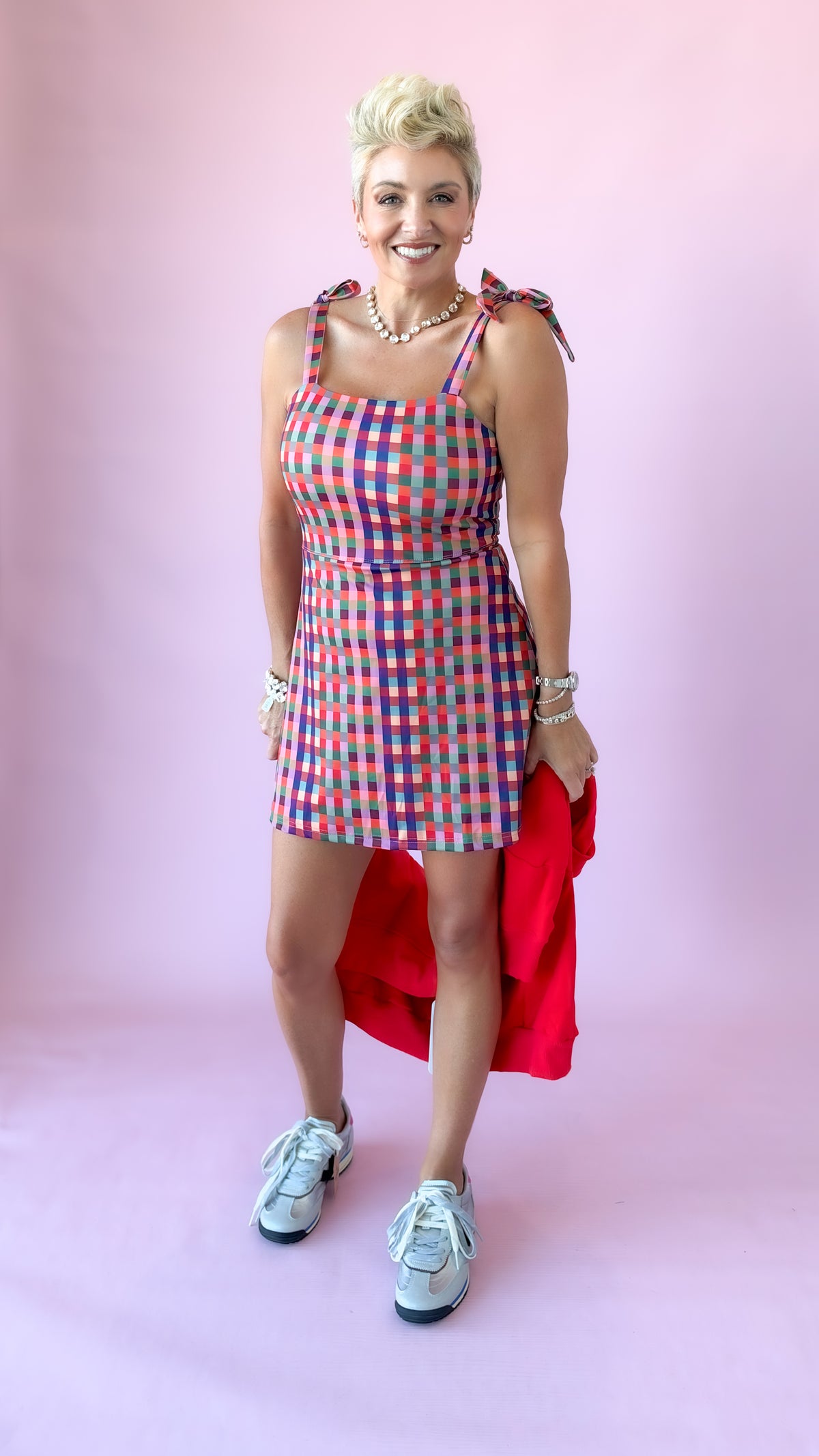 Full-length front view of gingham mini athletic dress with sneakers