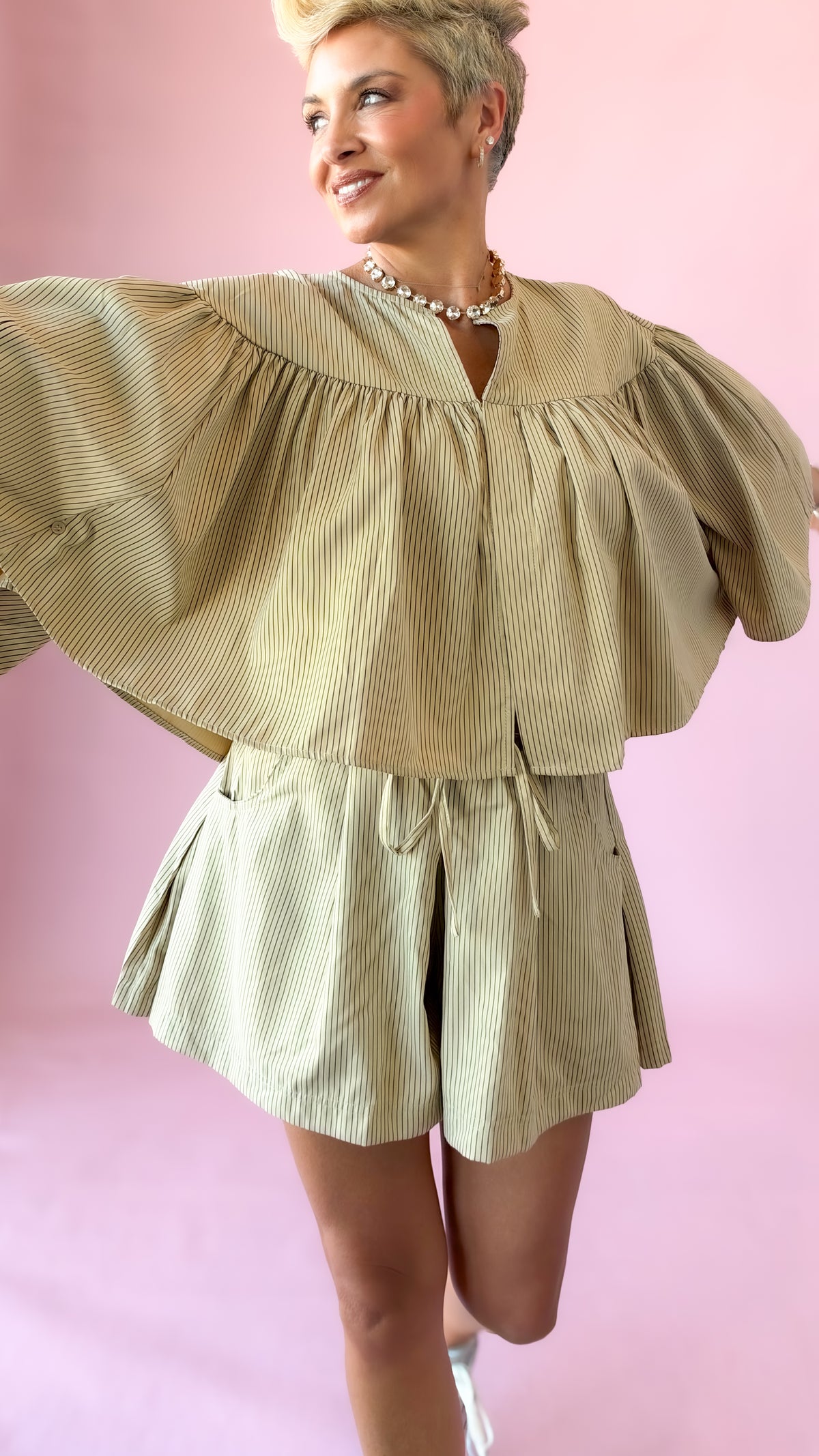 Beige striped elastic waist shorts with swing cape top, arms out