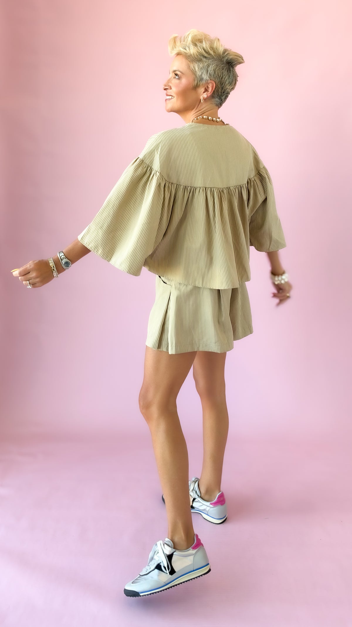 Side view of beige striped swing cape top
