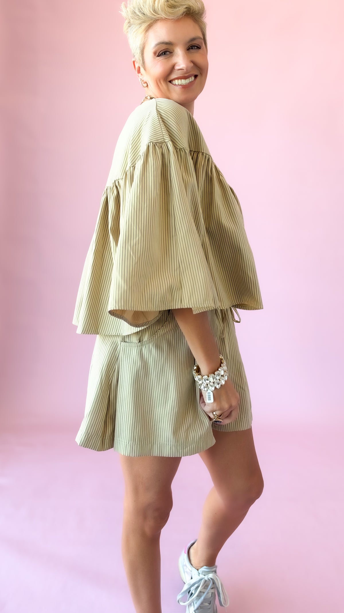 Close-up of beige striped swing cape top worn with matching shorts