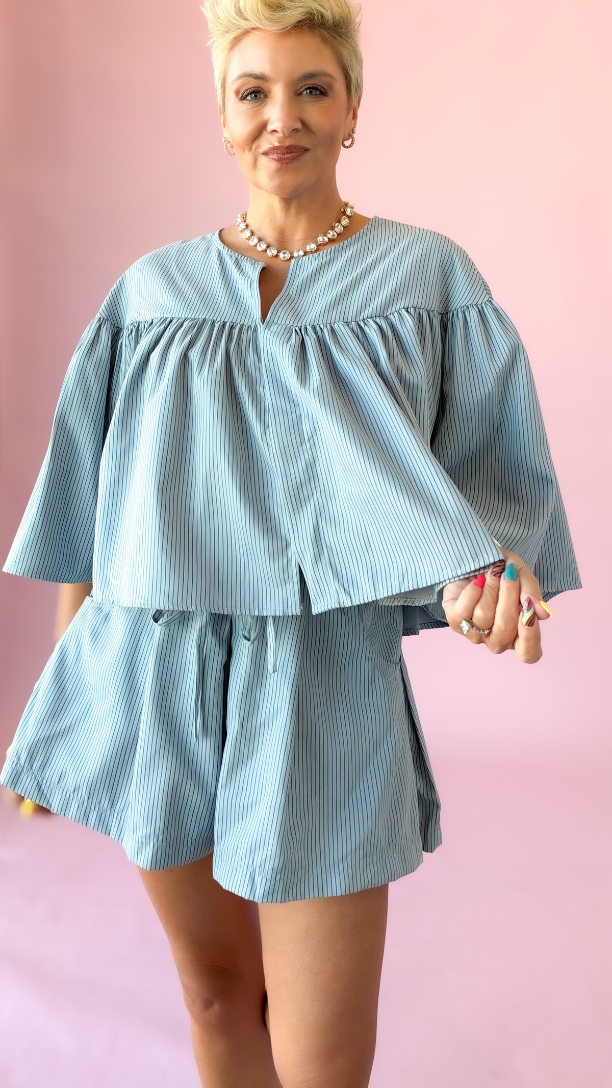 Close-up of light blue striped swing cape top with matching shorts