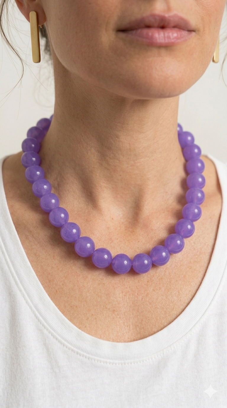 Person wearing a purple beaded necklace with a white background