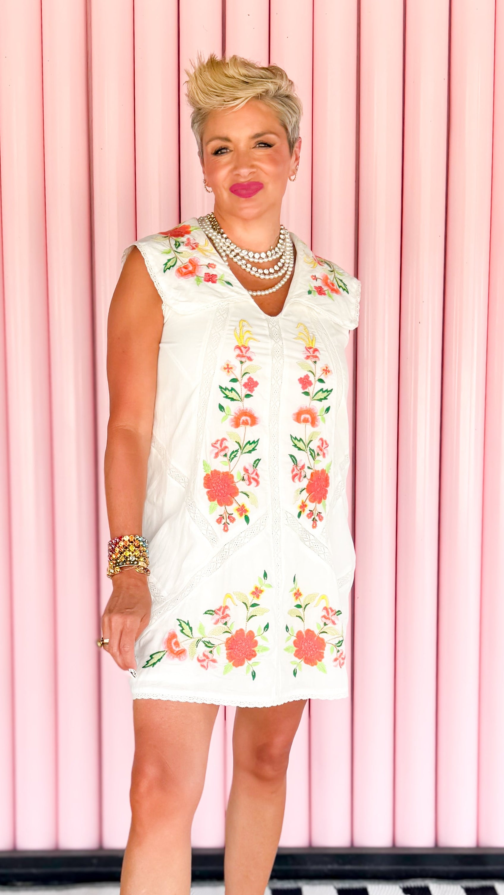 Woman wearing a floral dress against a pink curtain background