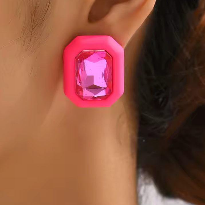 Pink gemstone earring on a person's ear