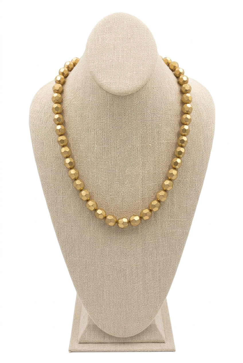 18-inch gold faceted bead necklace displayed on a beige linen jewelry bust