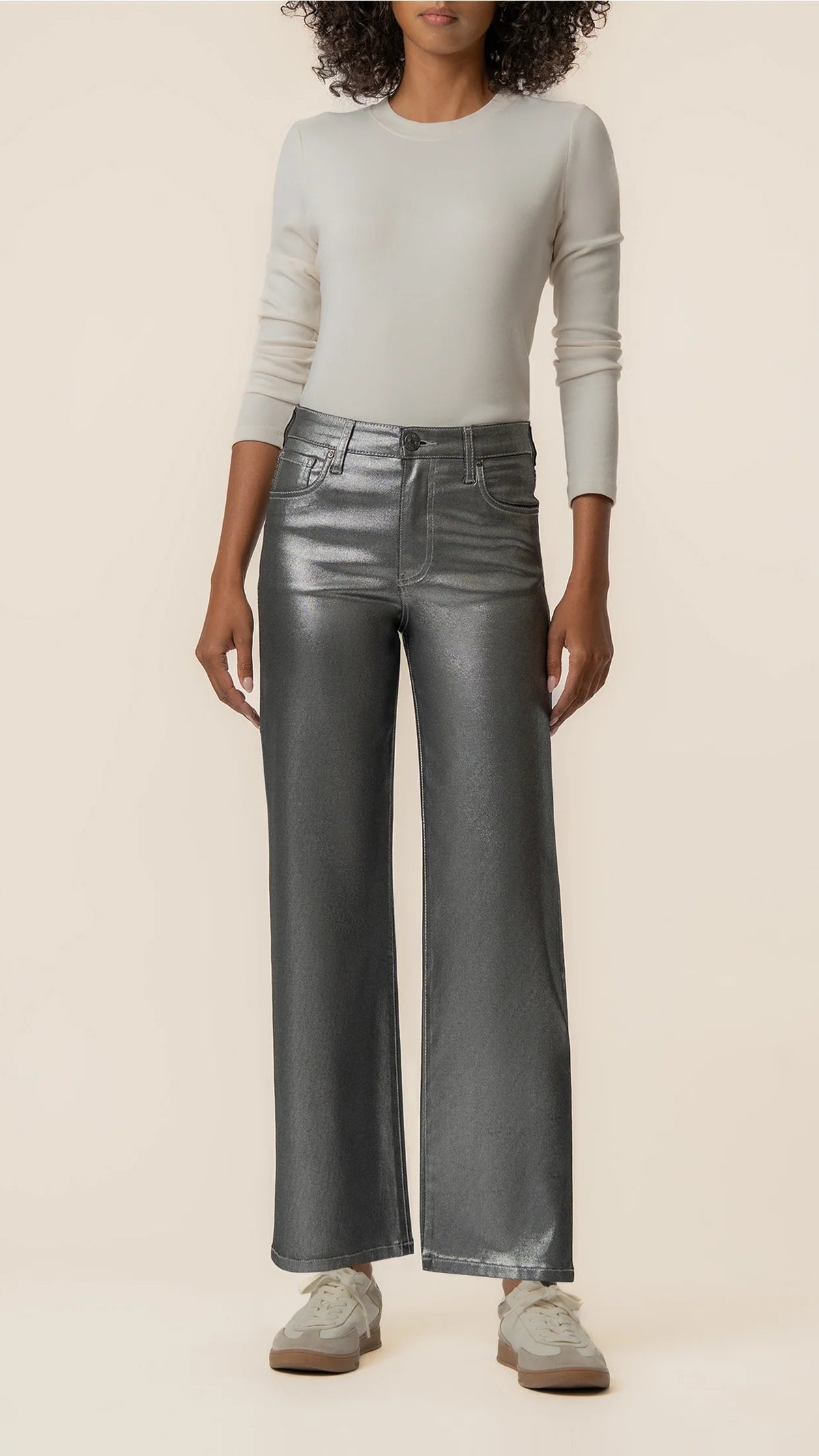 Front view of matte silver wide leg jeans styled with sneakers and a gray long sleeve top