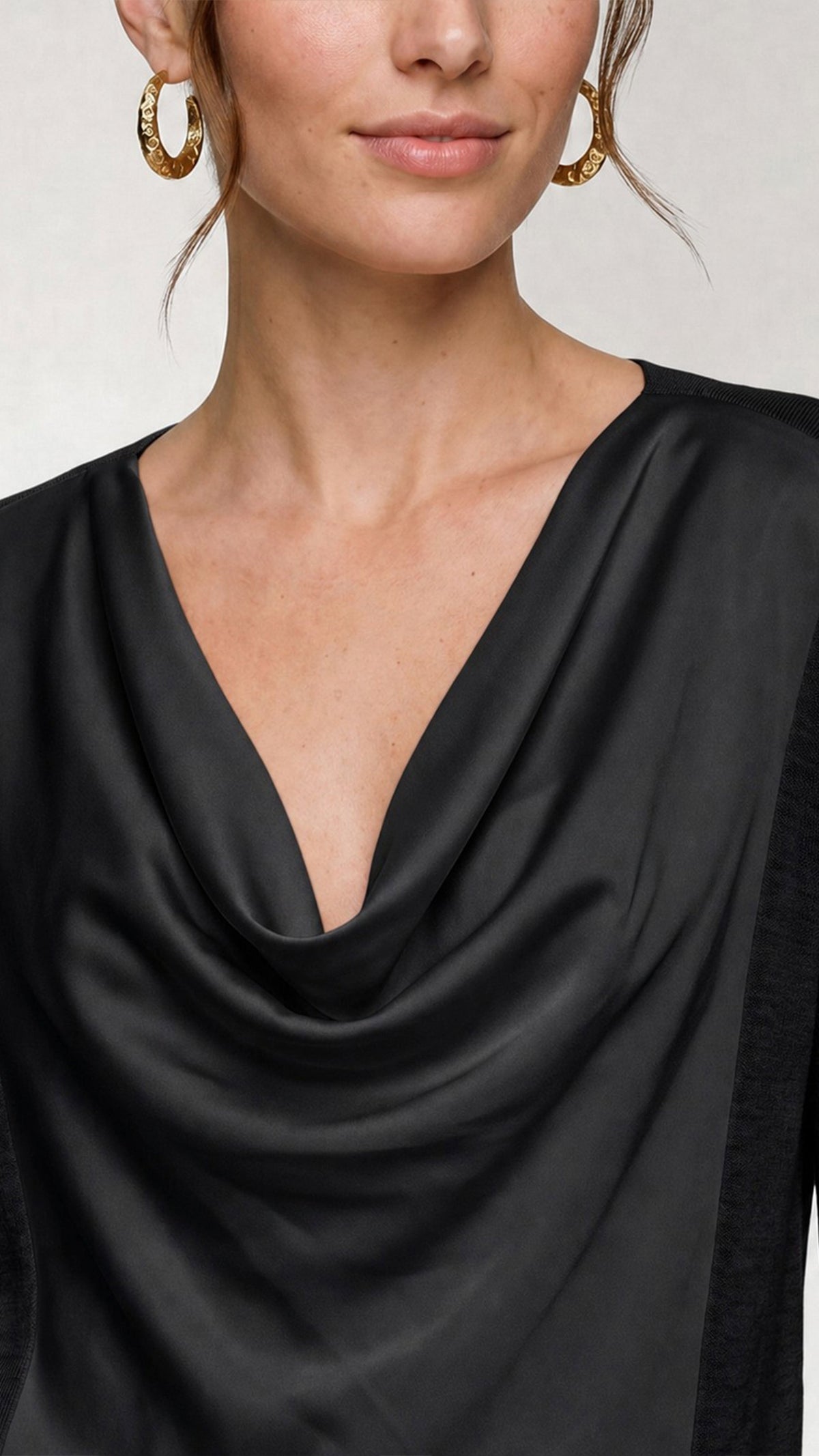 Close-up of draped cowl neckline on black mixed media sweater