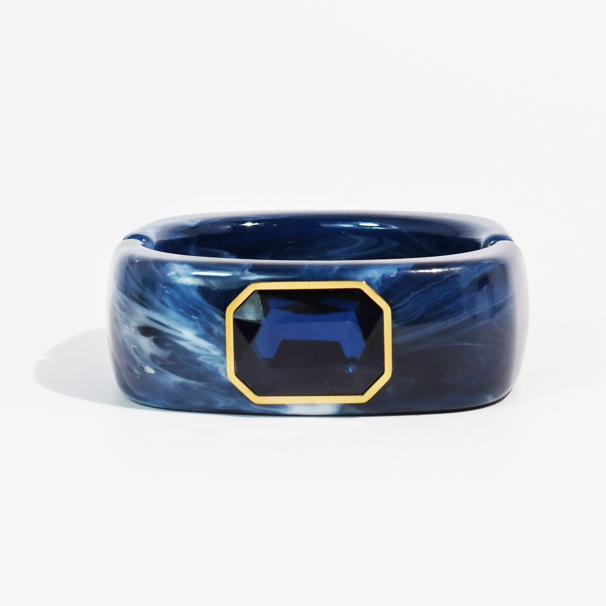 Navy swirled resin cuff bracelet with faceted sapphire blue octagon stone in gold-tone setting