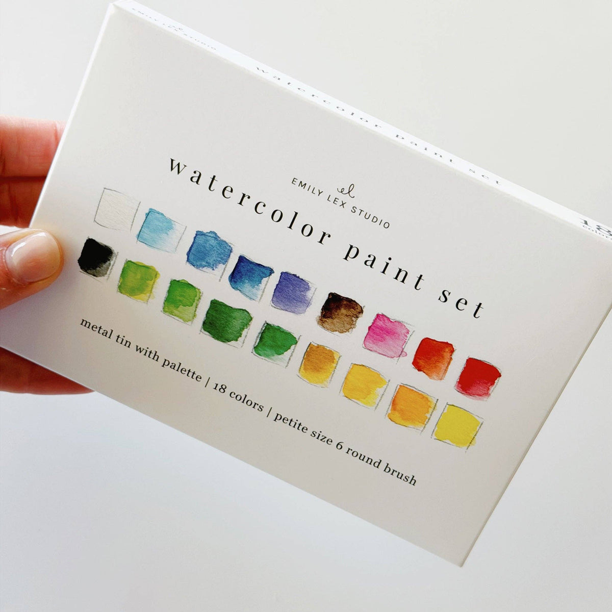 Hand holding the watercolor paint set color swatch card