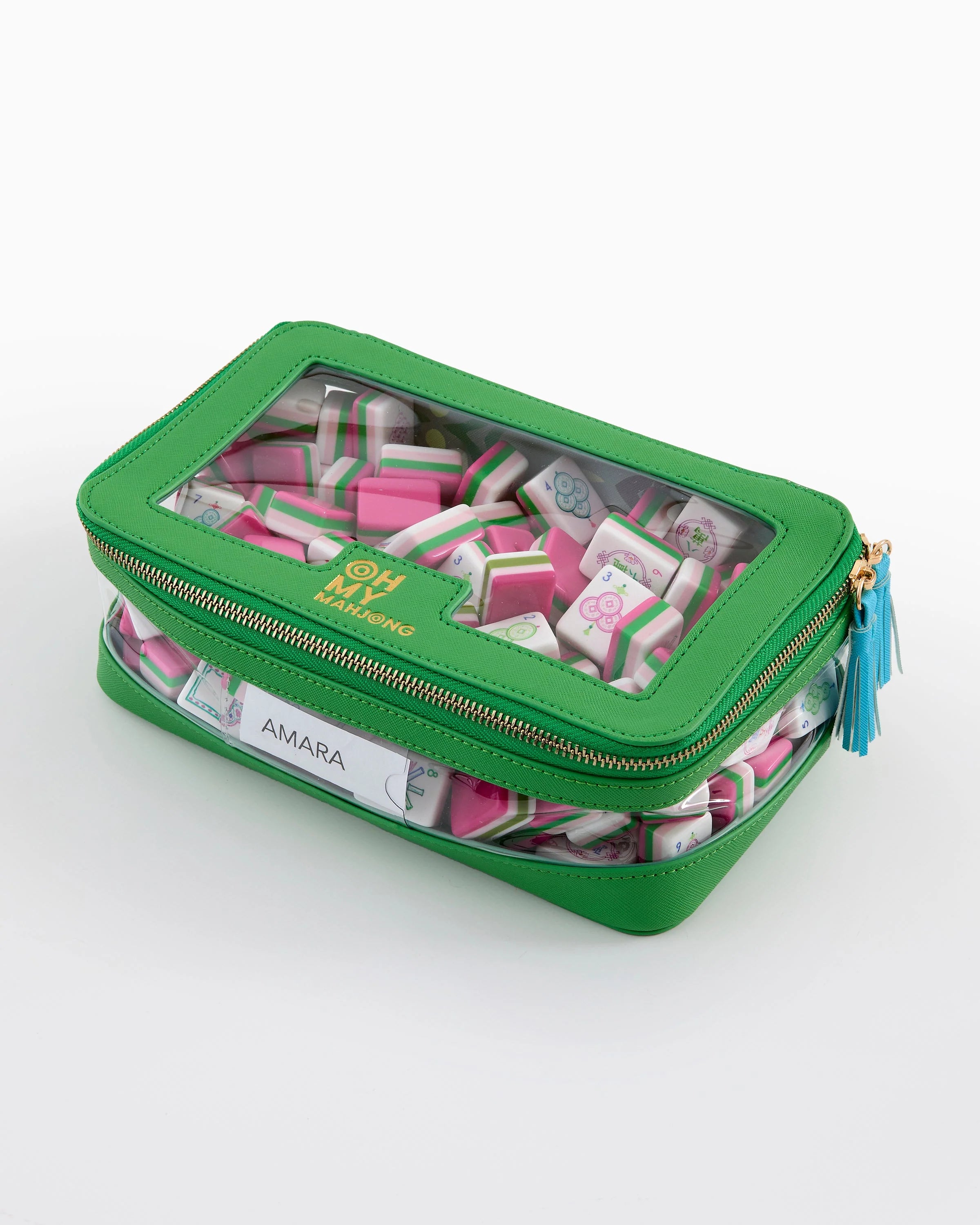 Green pencil case with pink and white items inside on a white background
