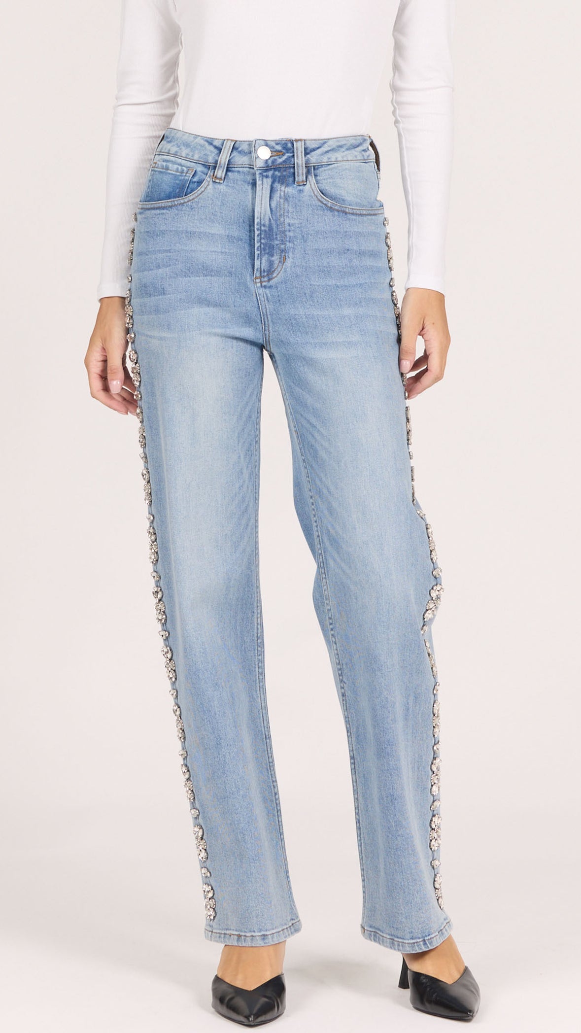 Front view of Dear John Holly straight leg jeans in gala blue light wash with rhinestone side seam trim, worn with a white long sleeve and black pointed heels