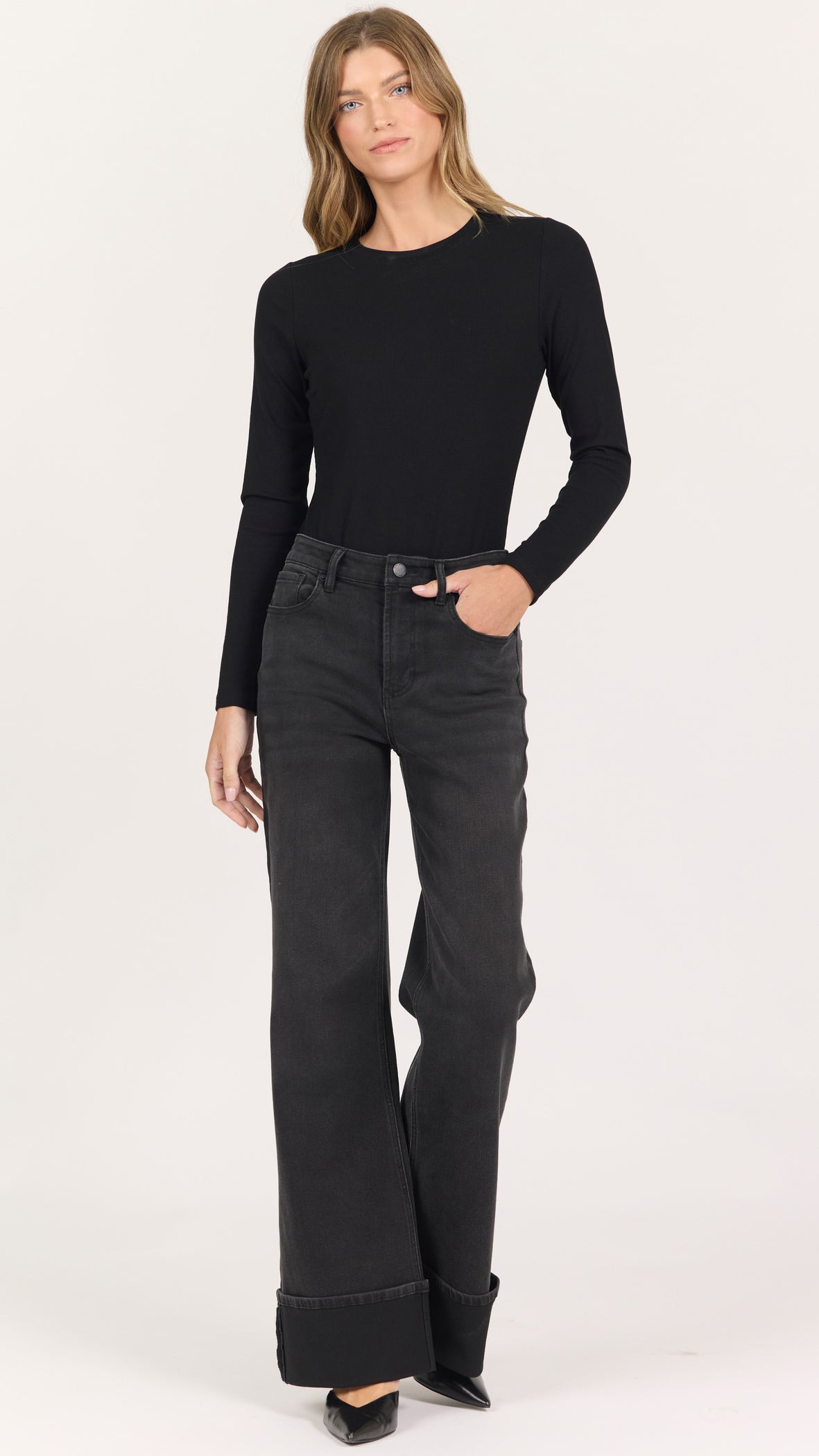 Full-length front view of Dear John Fiona wide leg jeans in midnight washed black worn with a black long sleeve and black pointed heels