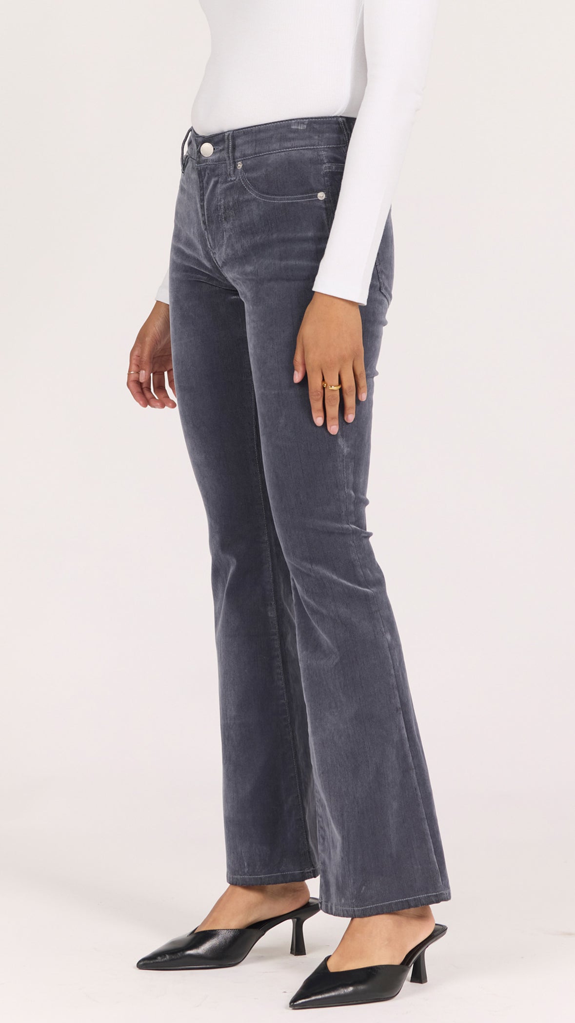 Three-quarter side view of smoke gray velvet Jaxtyn pants showing the bootcut leg and black mule heels