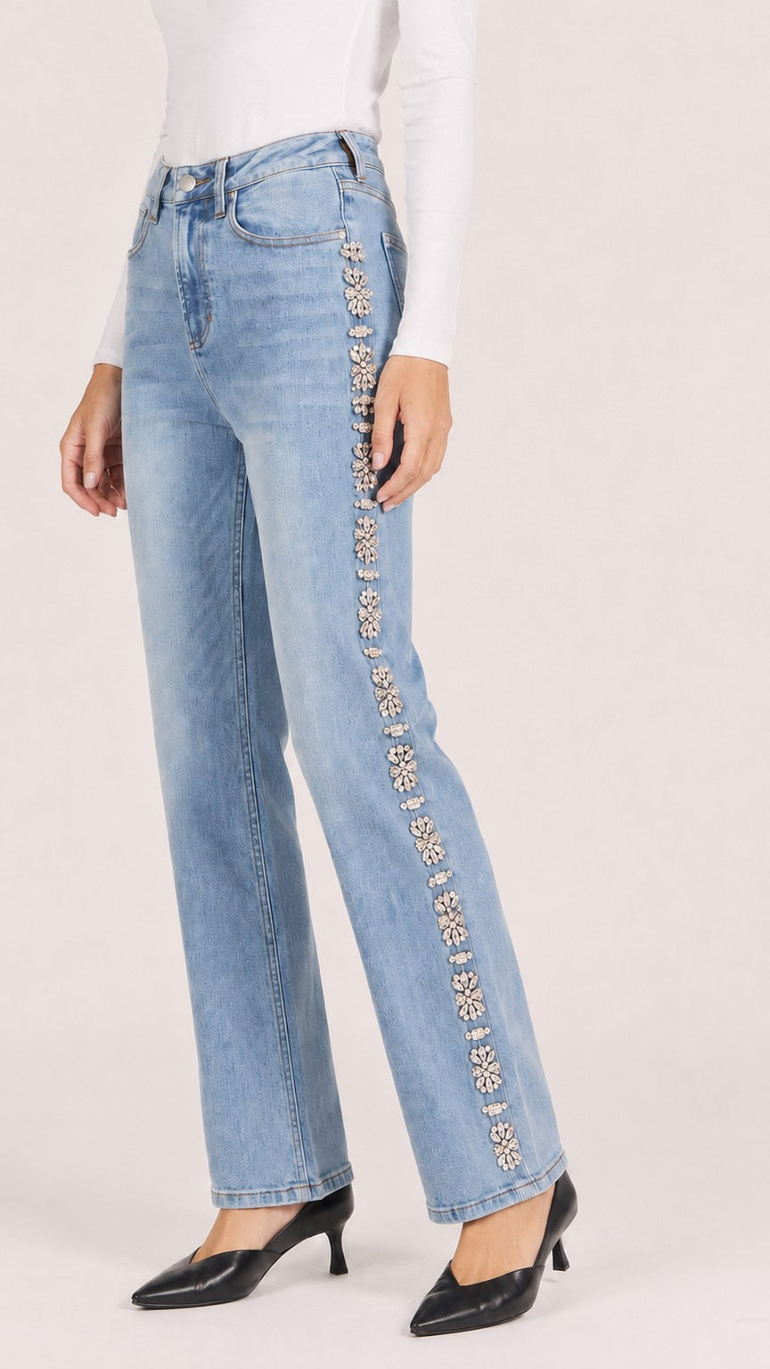 Side view of gala blue Holly straight leg jeans showing the rhinestone embellished side seam and black pointed heels