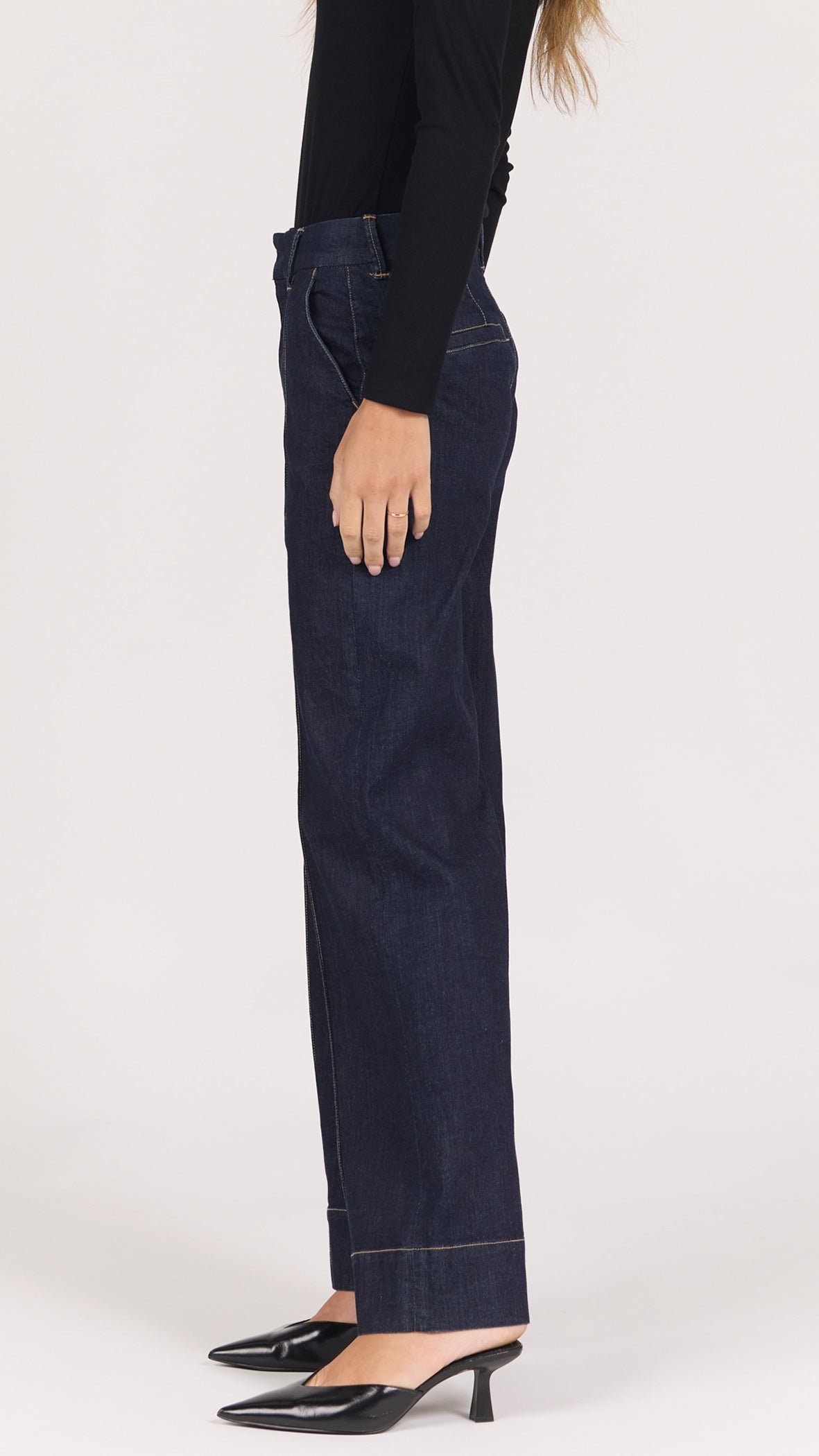 Three-quarter side view of equinox Brandy wide leg denim trousers with black pointed mule heels
