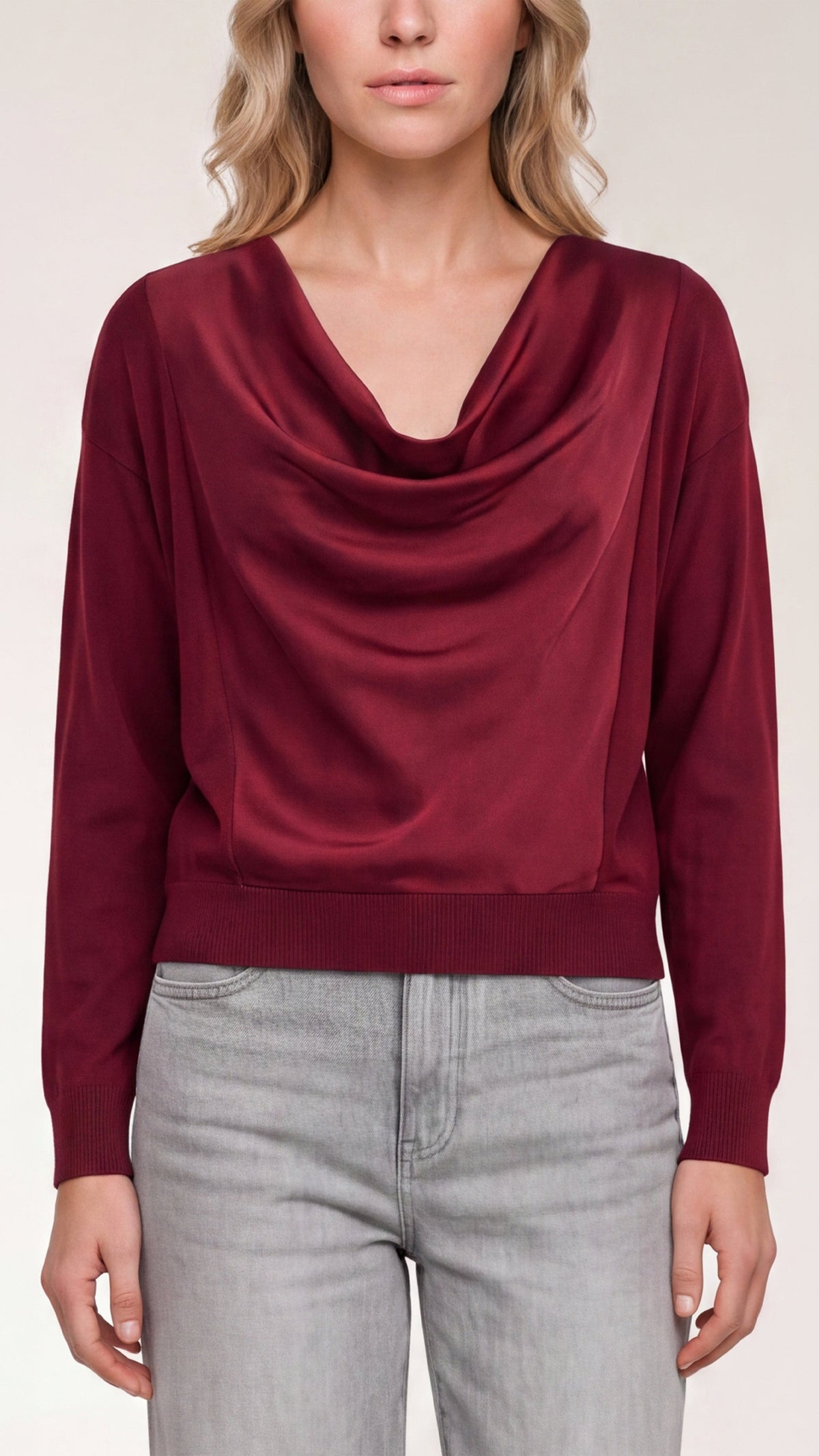 Model wearing merlot draped cowl neck mixed media sweater with light gray jeans, front view