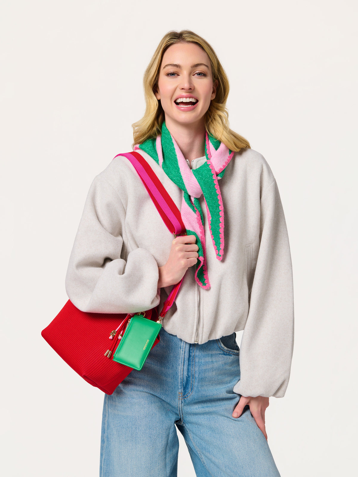 Shiraleah Joy Small Triangle Scarf in green and pink stripes, acrylic, polyester and wool knit, worn on model with red bag, lifestyle view