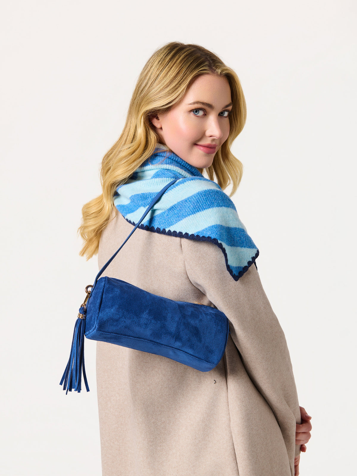 Shiraleah Joy Large Triangle Scarf in blue and light blue stripes, acrylic, polyester and wool knit, worn on model with blue bag, side view