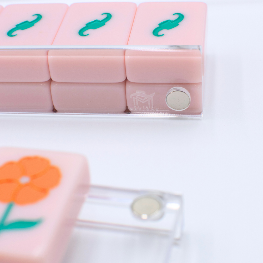 Close-up of pink and green tiles with floral design on a white background