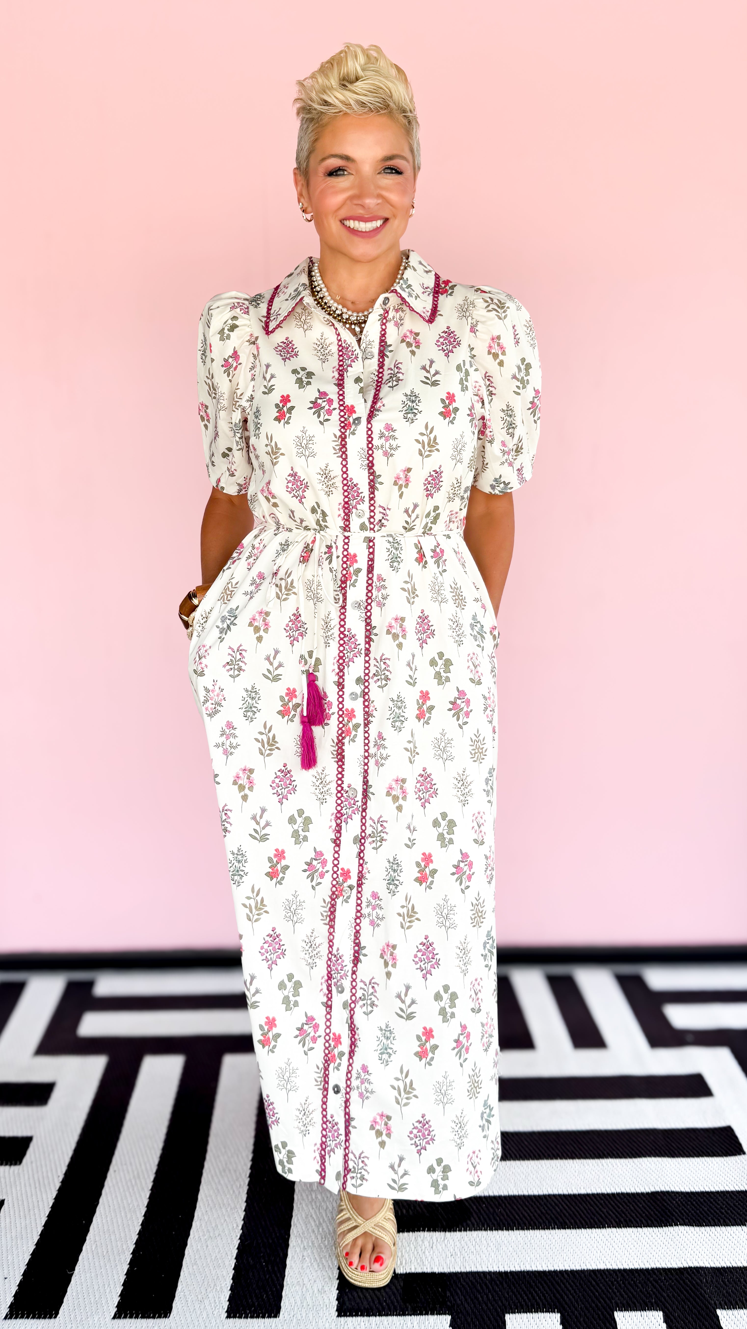 Woman wearing a floral dress with a pink background