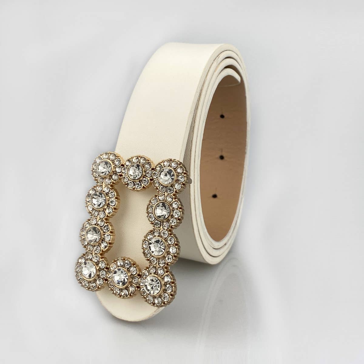 Beige belt with a decorative clasp on a light gray background