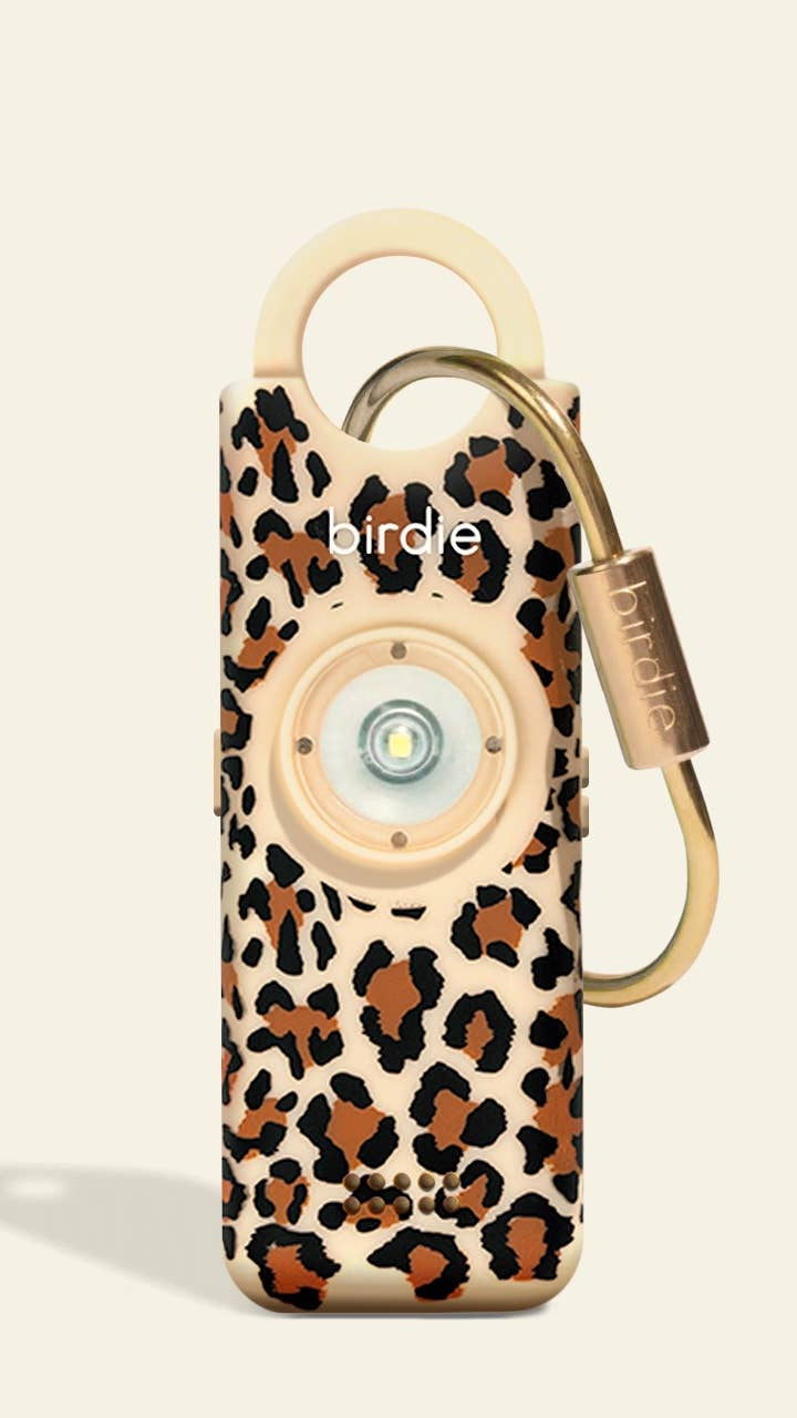 Leopard print device with a gold carabiner on a beige background