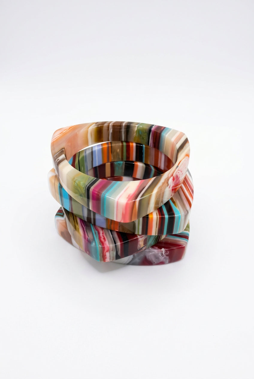 Triangle multicolor resin bangle bracelets in pink, red, teal and cream stripes, stacked view.